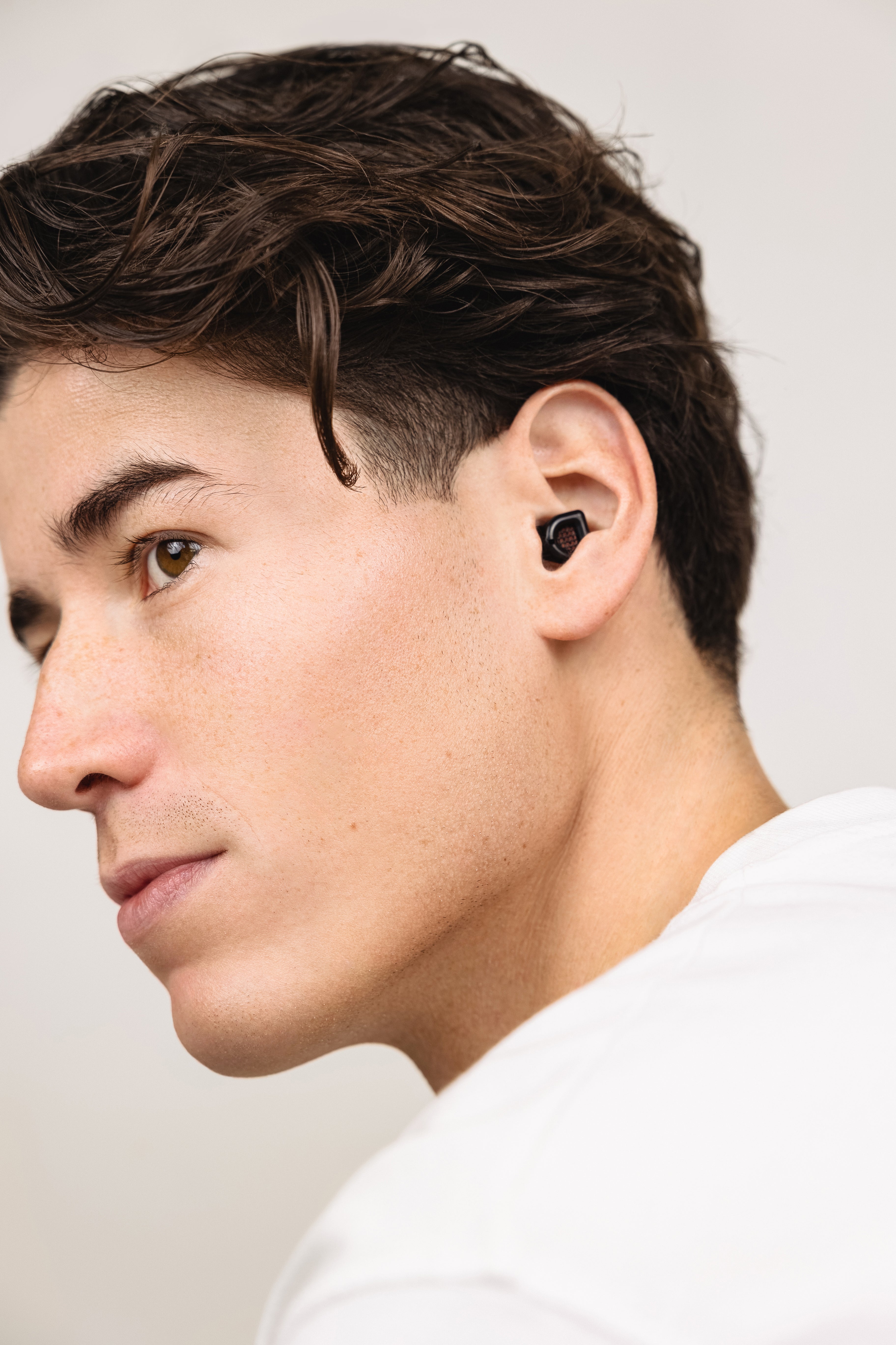 Man wearing a black MUSED earplug in his ear