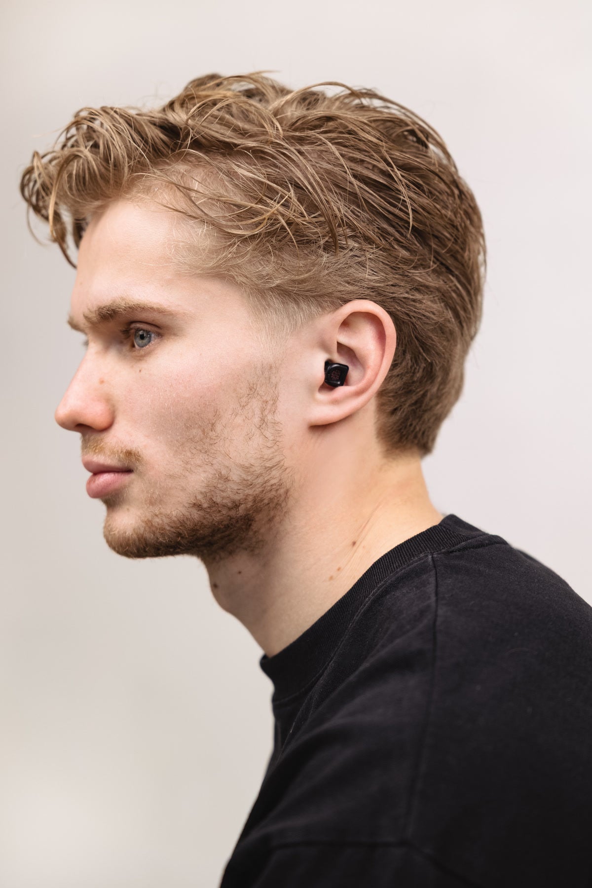 Man in black shirt wearing black MUSED earplugs