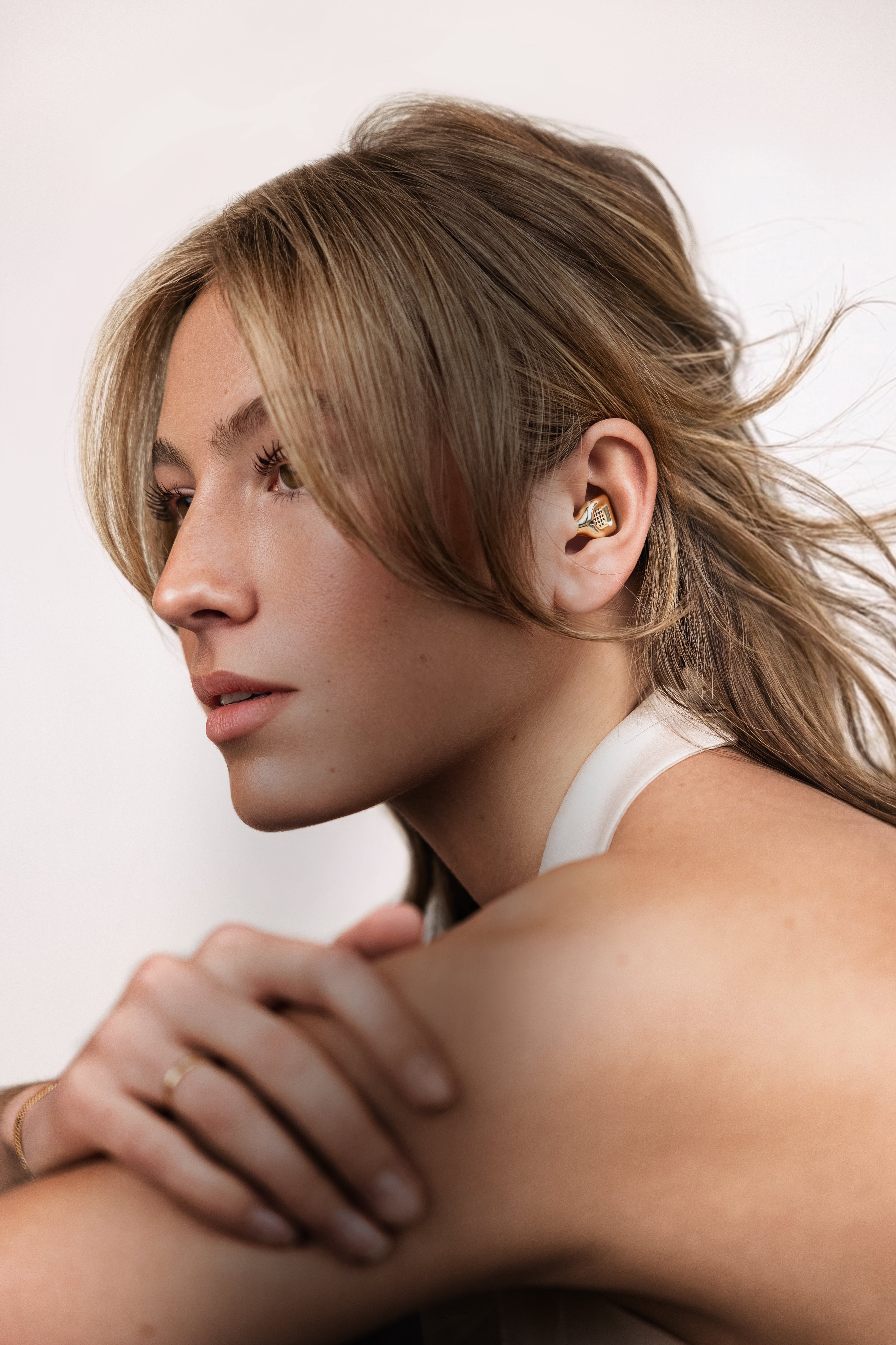 Woman with blonde hair wearing a gold MUSED earplug
