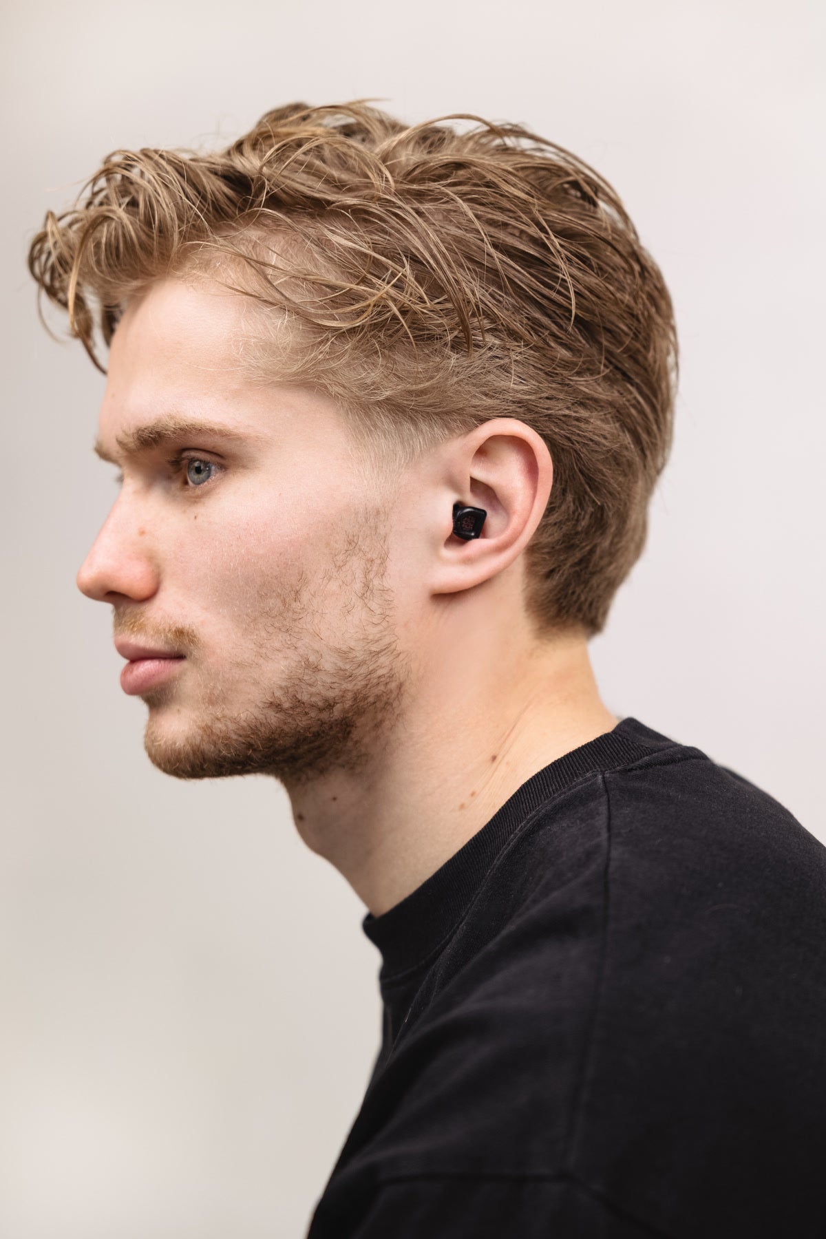 Man in black shirt wearing black MUSED earplugs