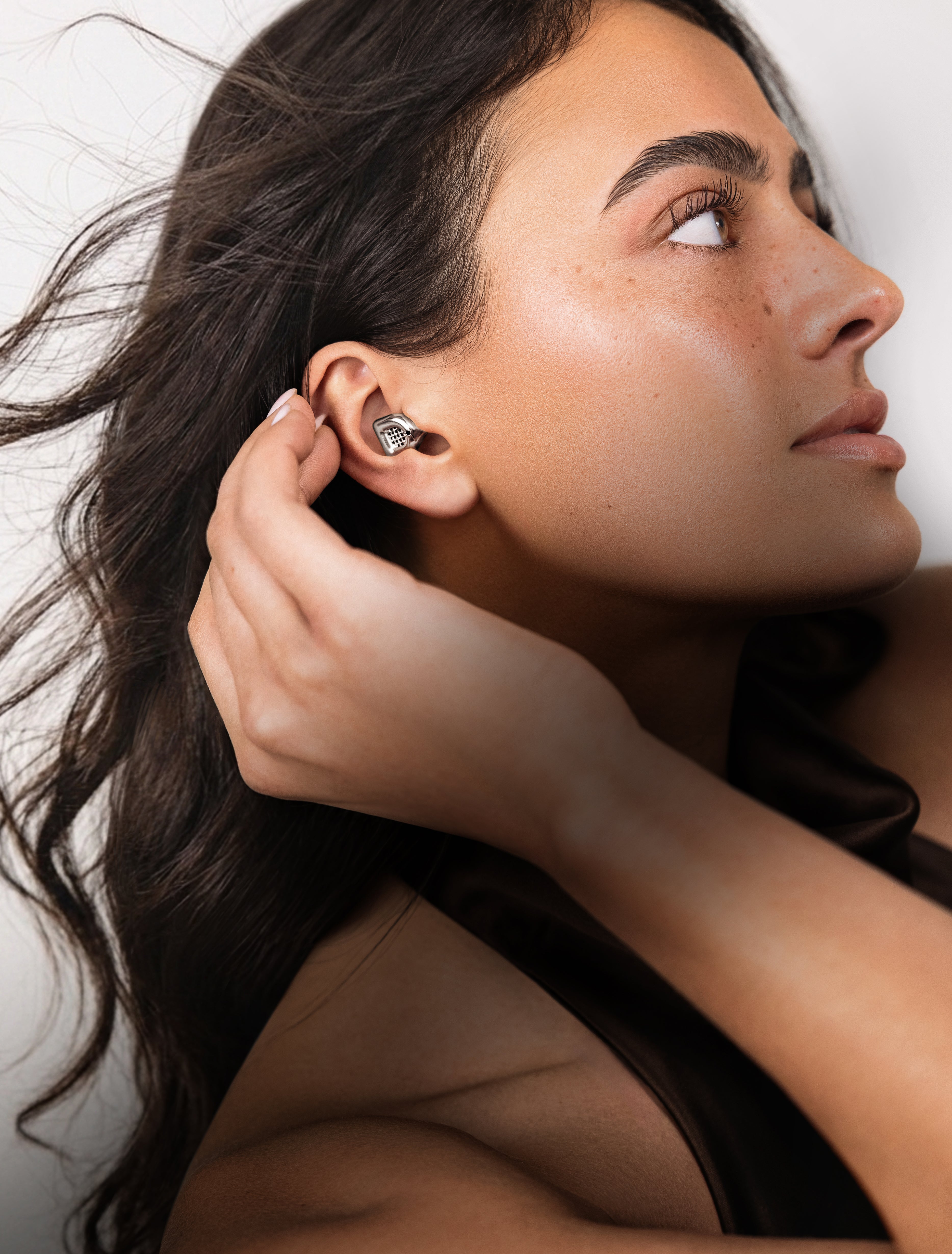 Woman wearing a silver MUSED earplug in her ear
